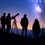 People with a telescope looking at the night sky