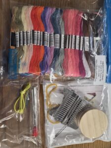 Darning loom kit with colorful embroidery threads.